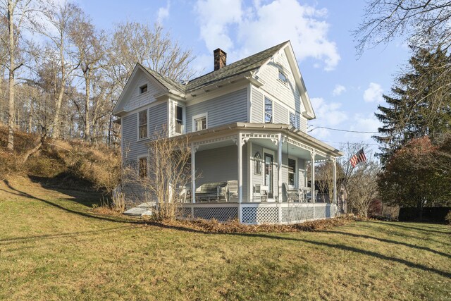 view of property exterior featuring a porch and a yard