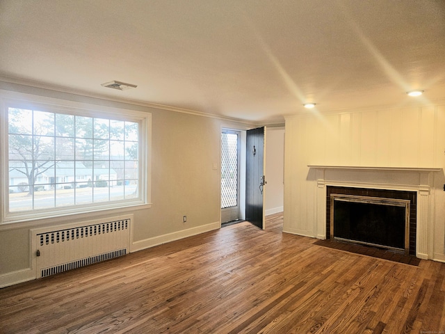 unfurnished living room featuring radiator, dark wood-type flooring, and ornamental molding