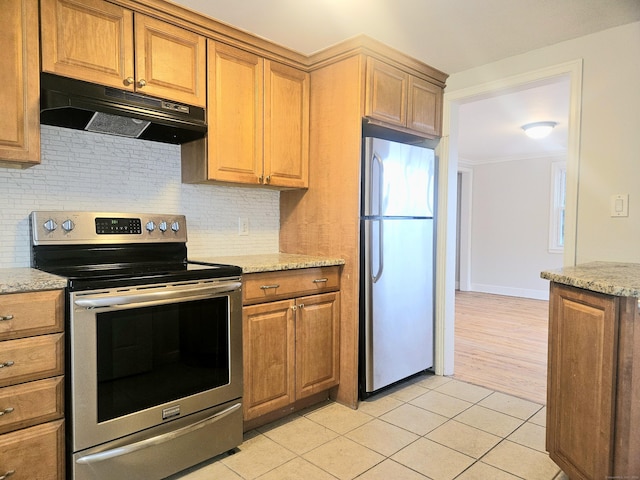 kitchen featuring light stone counters, stainless steel appliances, and light tile patterned flooring