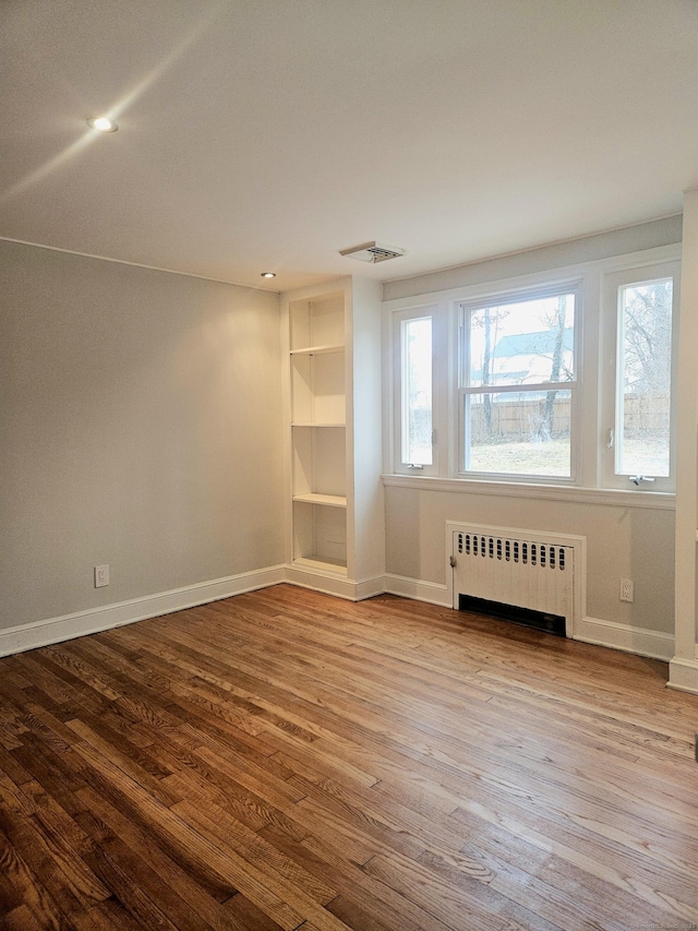 empty room with radiator and light wood-type flooring