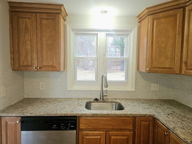 kitchen featuring sink, backsplash, light stone countertops, and dishwasher