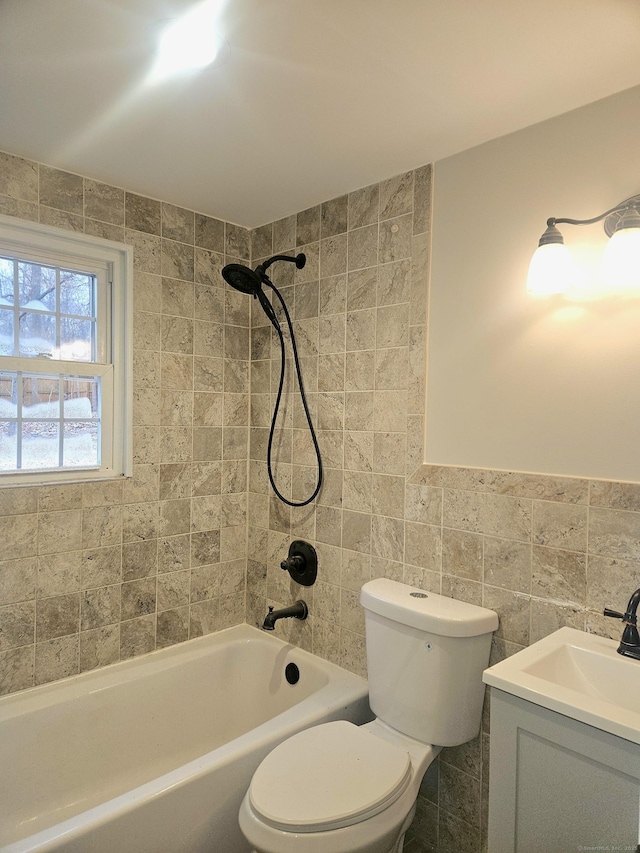 full bathroom with tiled shower / bath combo, vanity, tile walls, and toilet