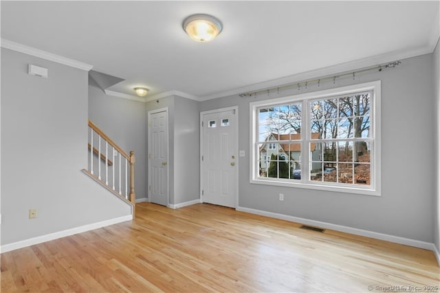 entryway featuring ornamental molding and light wood-type flooring