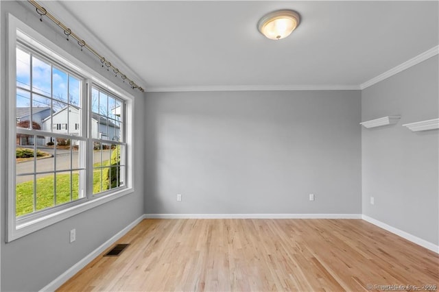 empty room featuring ornamental molding and light hardwood / wood-style flooring