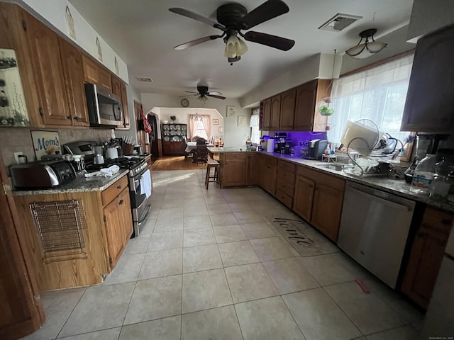 kitchen with a healthy amount of sunlight, stainless steel appliances, sink, and light tile patterned floors