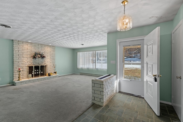 carpeted foyer with baseboard heating, a brick fireplace, and a textured ceiling