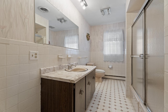 bathroom with a baseboard radiator, tile walls, vanity, and toilet