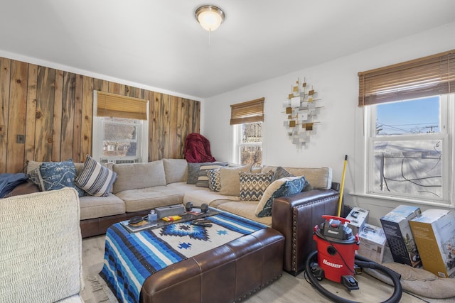 living room with wooden walls and light hardwood / wood-style floors