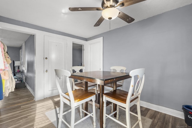 dining area with dark hardwood / wood-style floors and ceiling fan