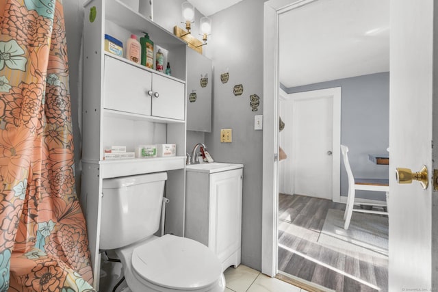 bathroom featuring toilet, sink, and hardwood / wood-style floors