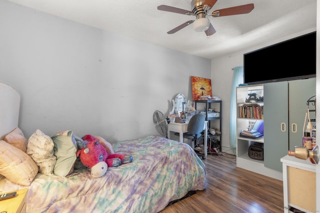 bedroom with ceiling fan, dark hardwood / wood-style floors, and a textured ceiling