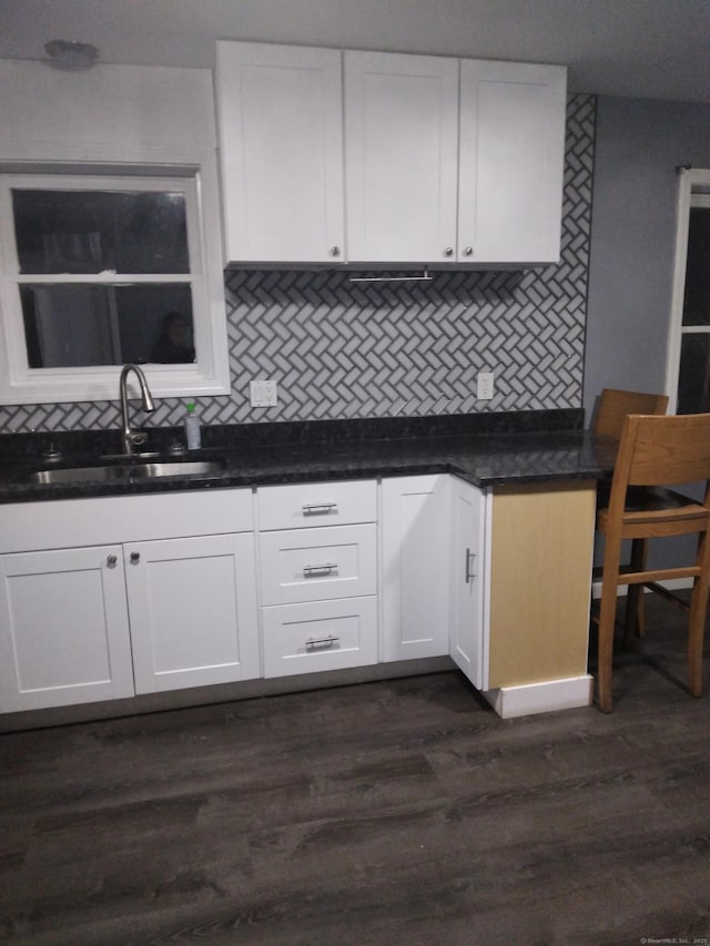 kitchen featuring dark hardwood / wood-style flooring, sink, decorative backsplash, and white cabinets