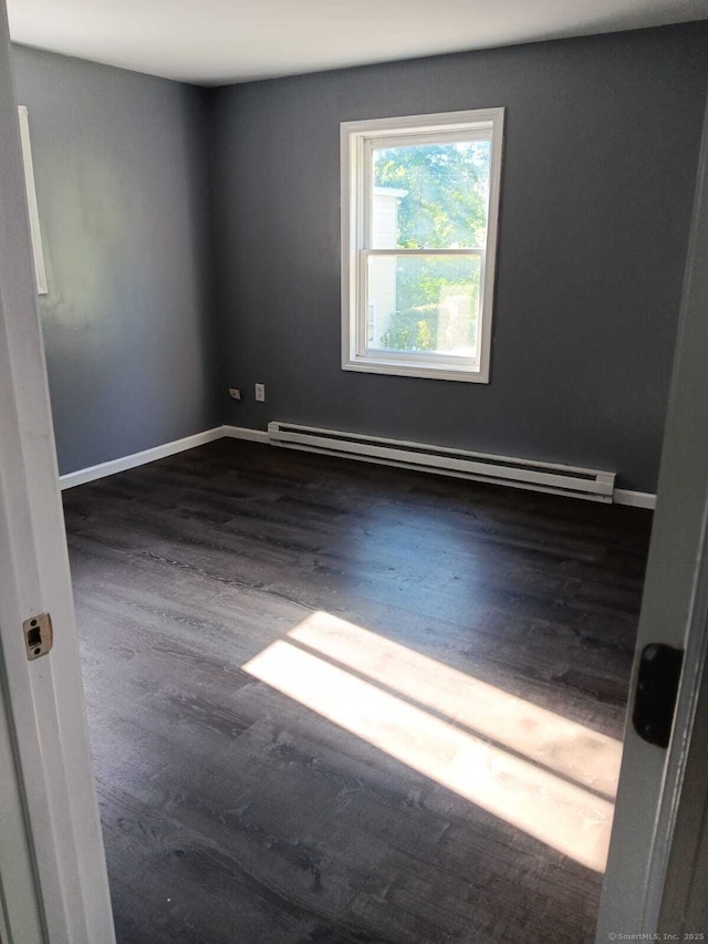 spare room featuring dark hardwood / wood-style flooring and baseboard heating