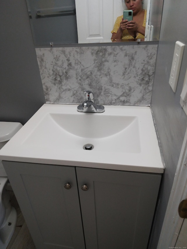 bathroom with tasteful backsplash and vanity