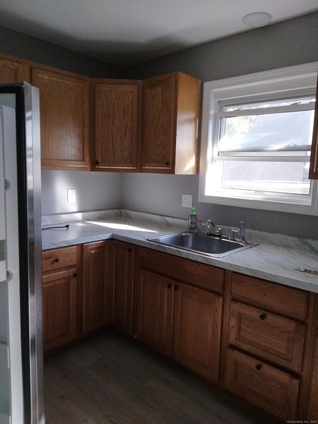 kitchen featuring dark hardwood / wood-style floors, sink, and stainless steel refrigerator