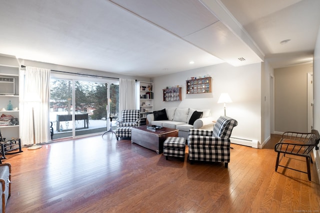 living room featuring wood-type flooring, a wall mounted AC, and baseboard heating