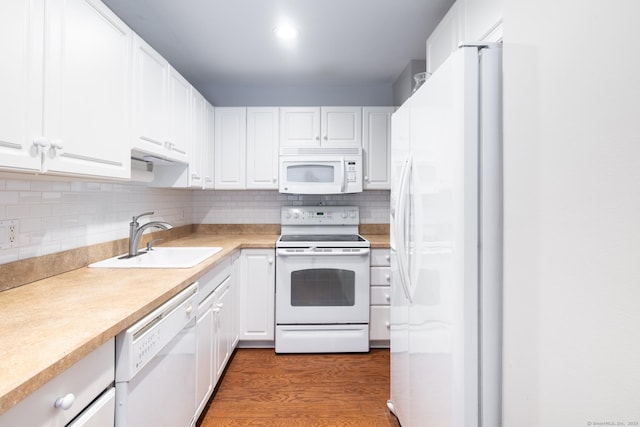 kitchen featuring hardwood / wood-style flooring, sink, white cabinets, and white appliances