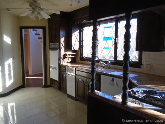 kitchen featuring light tile patterned floors, decorative backsplash, plenty of natural light, and white oven