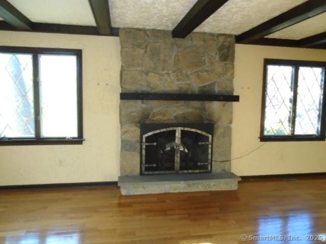 unfurnished living room with beamed ceiling and hardwood / wood-style flooring