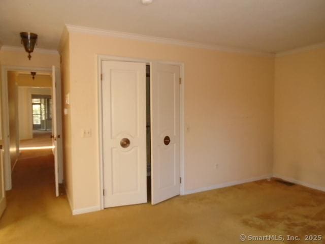 unfurnished room with crown molding and light colored carpet