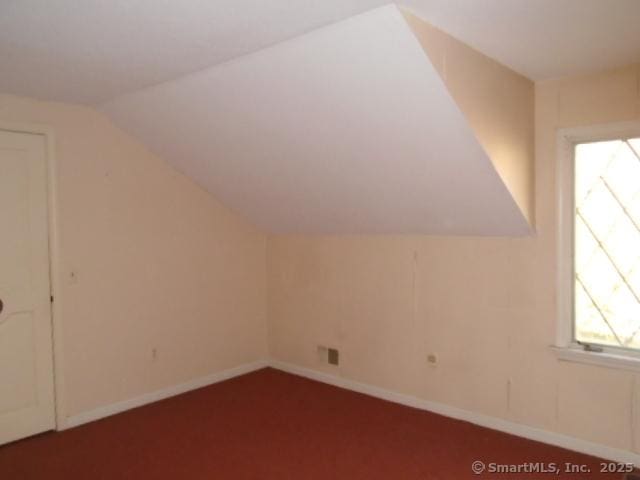 additional living space featuring vaulted ceiling