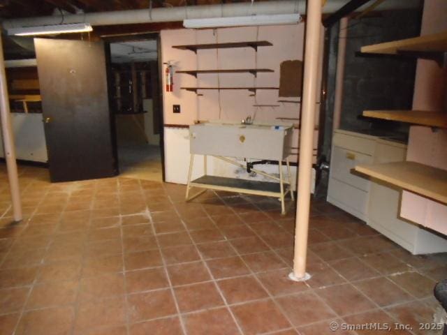 basement with tile patterned flooring and sink