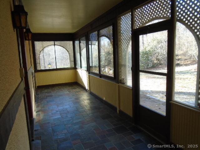 unfurnished sunroom with radiator heating unit