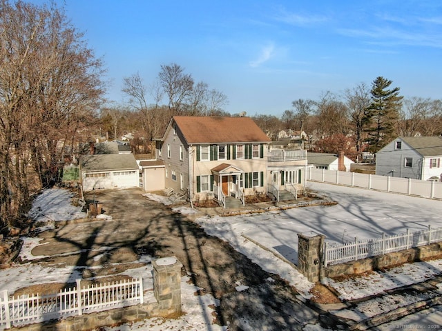 view of front of property featuring a garage, a balcony, and an outbuilding