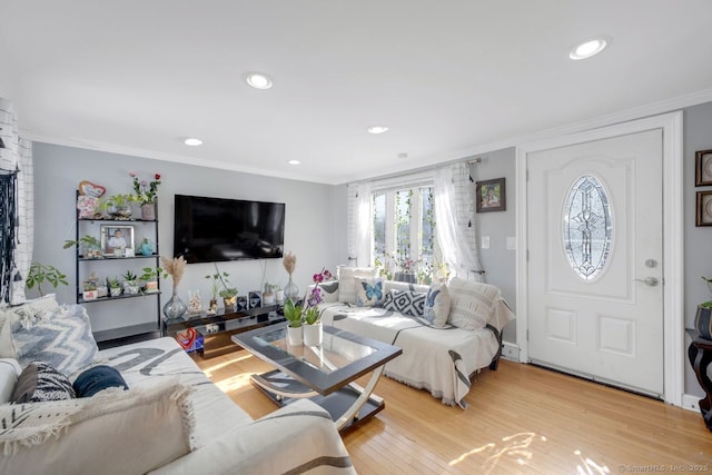 living room featuring ornamental molding and light hardwood / wood-style floors