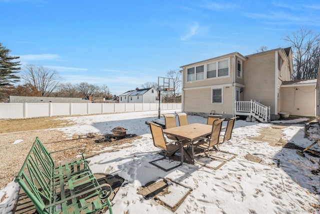 snow covered patio featuring an outdoor fire pit