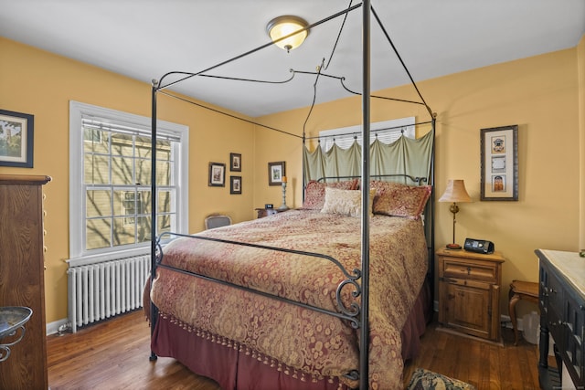 bedroom featuring radiator heating unit and dark hardwood / wood-style flooring