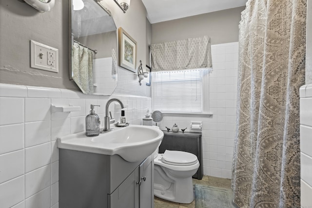 bathroom with vanity, tile walls, and toilet