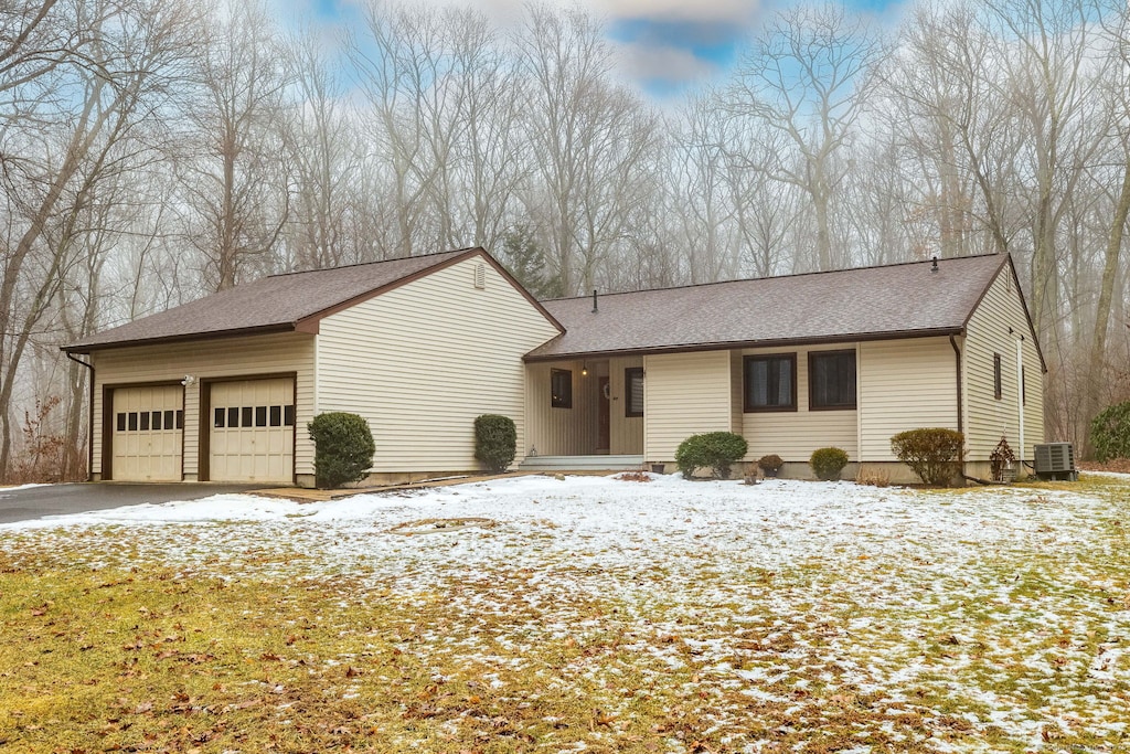 view of front of house with a garage and central air condition unit