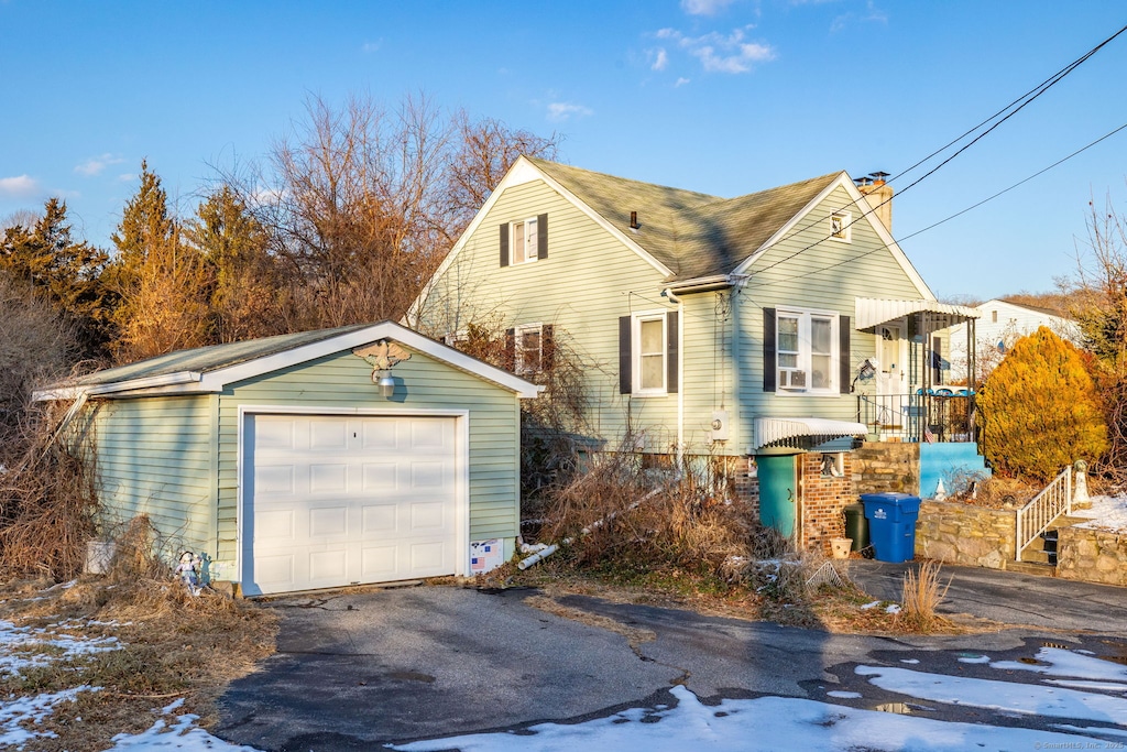 exterior space with a garage and an outbuilding