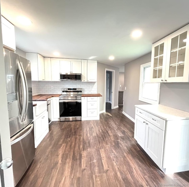 kitchen featuring backsplash, stainless steel appliances, dark hardwood / wood-style floors, and white cabinets