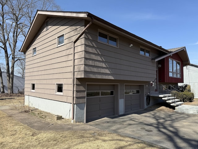 view of side of home featuring an attached garage and driveway