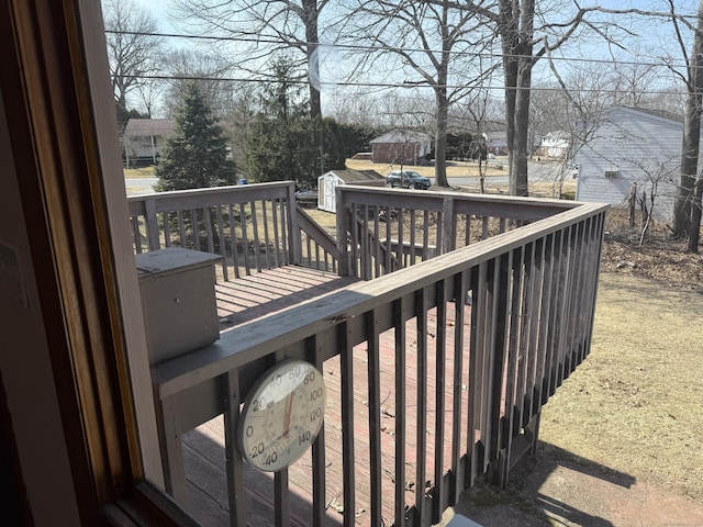 wooden deck featuring a shed and an outdoor structure