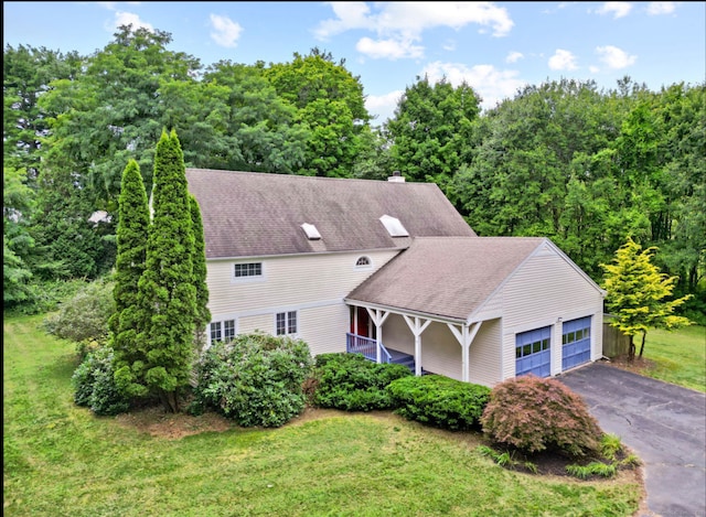 view of front of property featuring a garage, a front yard, and covered porch