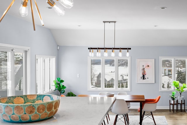 dining space featuring lofted ceiling and wood-type flooring