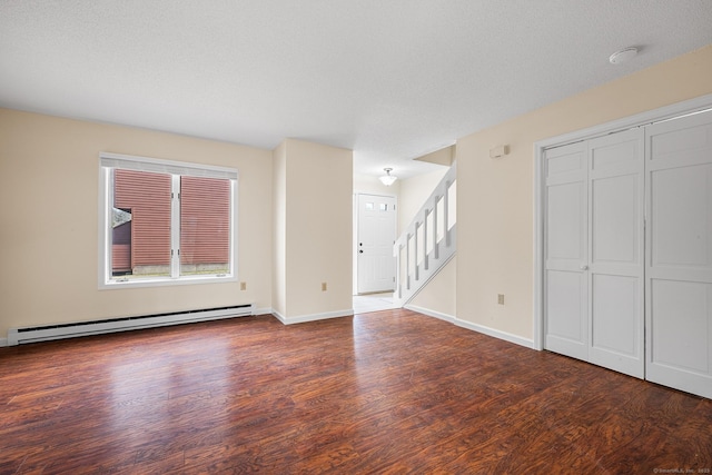 unfurnished living room with baseboard heating, dark hardwood / wood-style flooring, and a textured ceiling