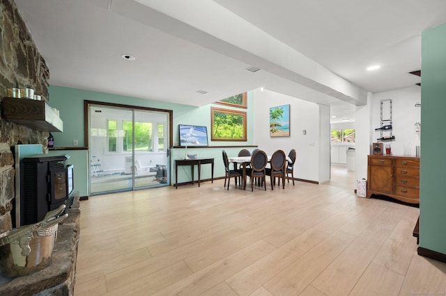 interior space featuring a healthy amount of sunlight, a wood stove, and light hardwood / wood-style floors