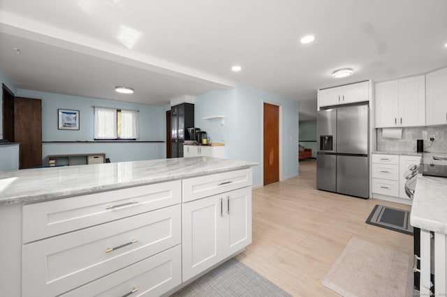 kitchen featuring light hardwood / wood-style flooring, white cabinetry, stainless steel refrigerator with ice dispenser, light stone counters, and decorative backsplash