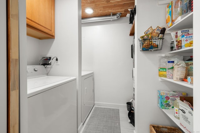 washroom featuring cabinets and washing machine and clothes dryer