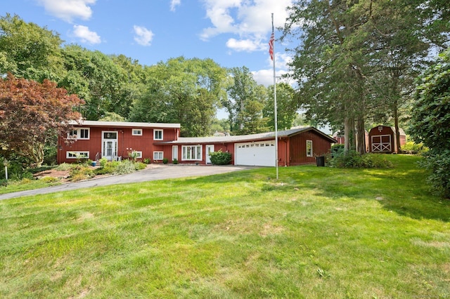 view of front of property with a garage, a front yard, and a storage shed