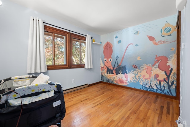 bedroom with hardwood / wood-style floors and baseboard heating