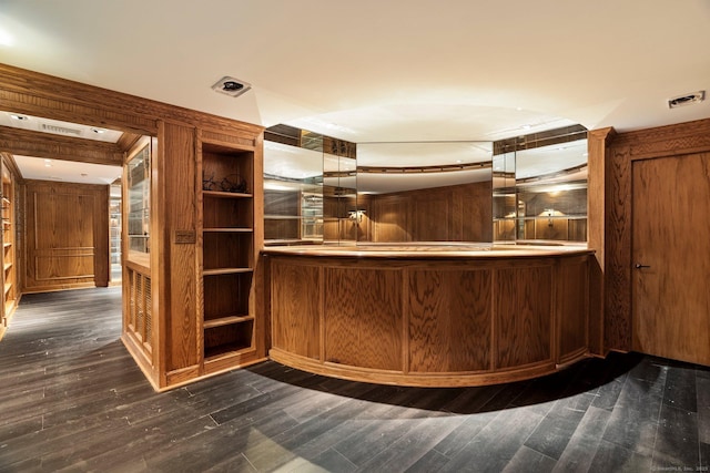 bar featuring hanging light fixtures, dark hardwood / wood-style flooring, and wood walls