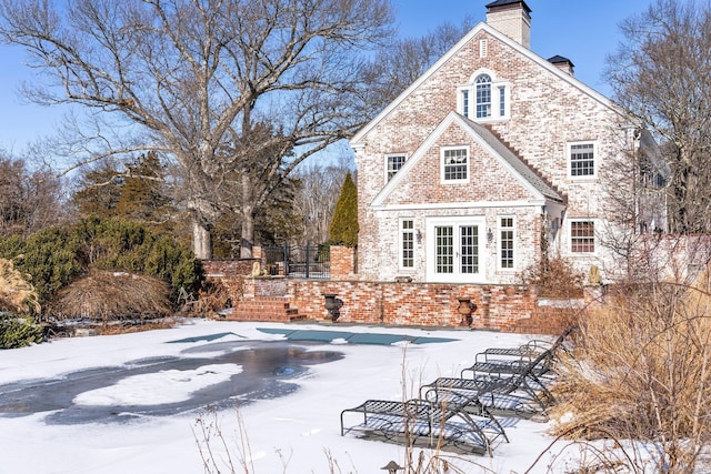 view of snow covered back of property