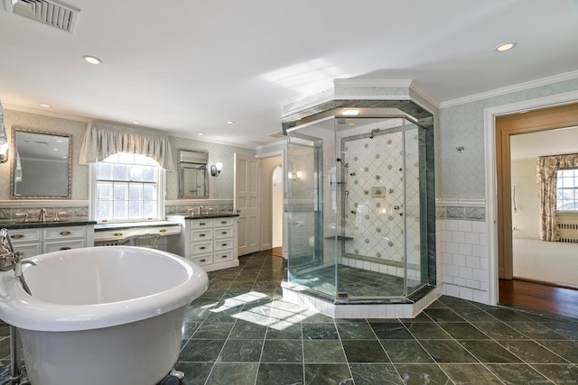 bathroom featuring independent shower and bath, vanity, ornamental molding, and tile walls