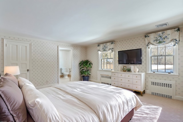 bedroom with multiple windows, radiator, and ensuite bathroom