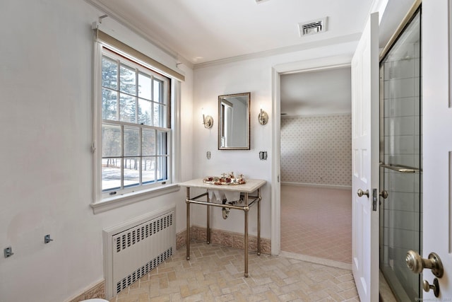 bathroom with ornamental molding and radiator